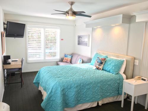 曼哈顿海滩海景海滩假日酒店的一间卧室配有一张带蓝色棉被的床