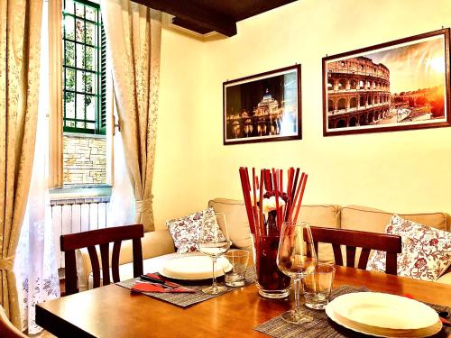 罗马La Tana al Flaminio的餐桌,配有盘子和酒杯