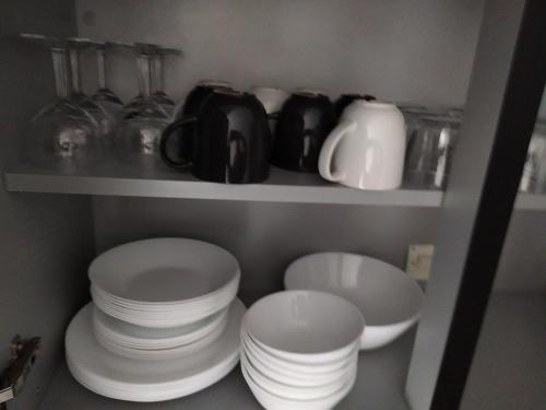 勒克佐Bel appartement en plein coeur de ville的厨房里装有盘子、杯子和盘子的架子