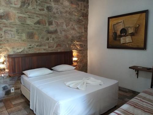 伊加图Art Hotel Cristal de Igatu的卧室配有白色的床