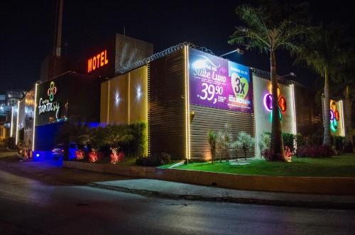 贝洛奥里藏特莫泰幻想3情趣酒店（仅限成人）的一座晚上有 ⁇ 虹灯标志的建筑