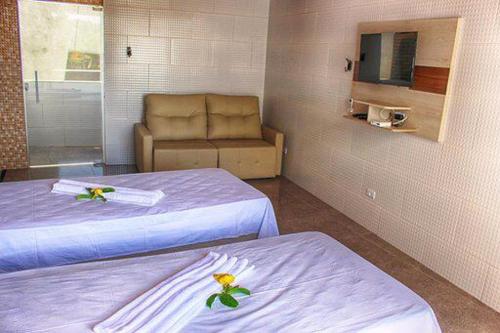 科鲁里皮FLAT RIOMAR的酒店客房,设有两张床和一张沙发
