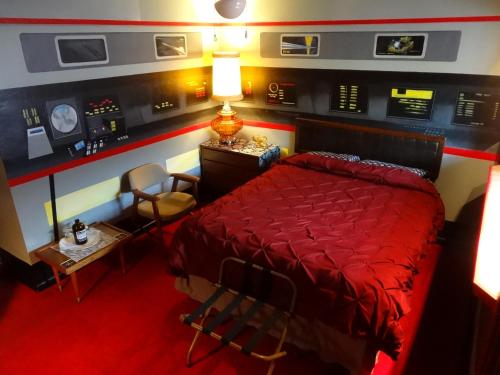 北本德The Star Trek - USS Enterprise Room at the Itty Bitty Inn的一间卧室配有红色的床和桌椅