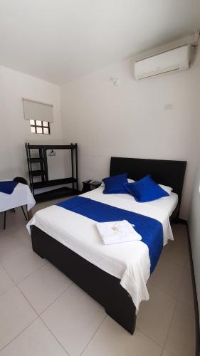 洛佩斯港Hotel Zenit de Colombia的一间卧室配有一张带蓝色枕头的大床