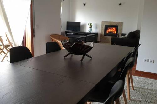 孔迪镇Carminho beach house的客厅配有桌椅和壁炉