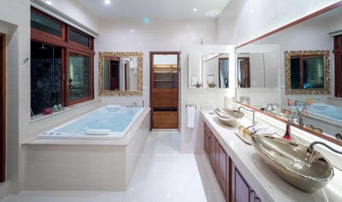 清迈Modern Love Villa的浴室设有2个水槽和1个带2个镜子的浴缸