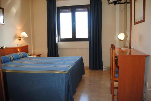 拉拉斯特里拉埃尔米拉多旅馆的一间卧室设有蓝色的床和窗户。