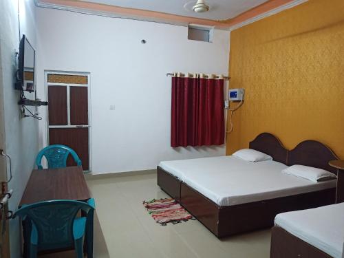 Kushinagarvindhyvasini guest house的一间卧室配有床和红色窗帘