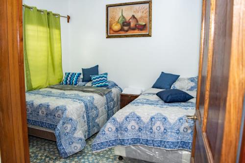 JuayúaMixtepek的卧室配有两张床,墙上挂着一幅画