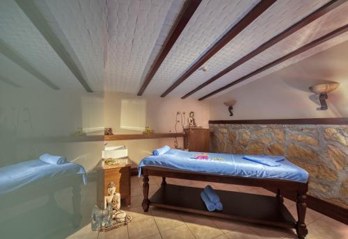 安塔利亚临海家庭度假酒店的一间卧室设有两张床和石墙