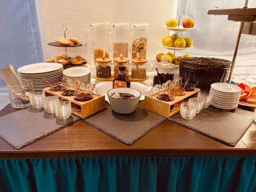 科隆Hotel Arena的盘子,杯子,食物和甜点的桌子