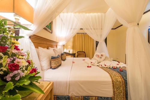 勒吉安雷吉安乐园酒店的一间卧室,床上放着鲜花