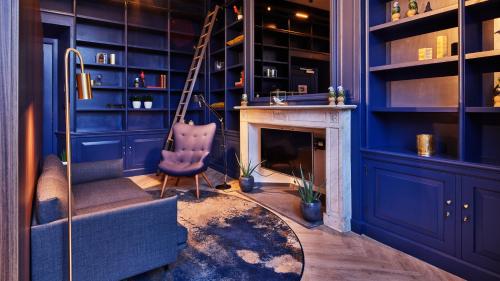 海牙Staybridge Suites The Hague - Parliament, an IHG Hotel的蓝色的客房设有椅子和壁炉
