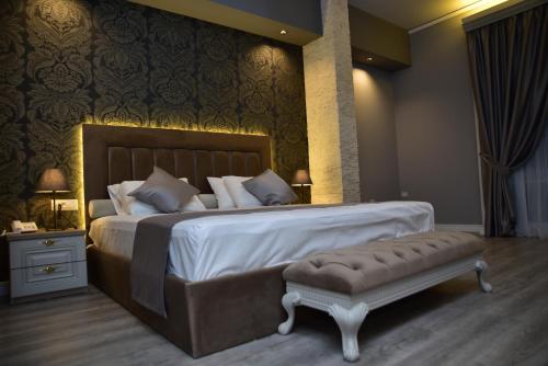 地拉那The King Resort的一间卧室配有一张大床,内有长凳