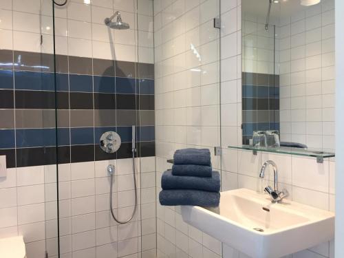 东卡佩勒帕兰杜酒店的浴室配有水槽和带蓝色毛巾的淋浴