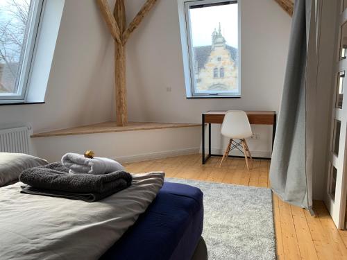 奥斯纳布吕克Villa am Wall的卧室配有一张床、一张书桌和窗户。