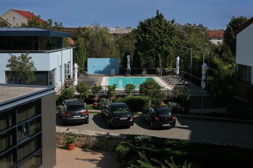 蒂米什瓦拉雷吉纳蓝色酒店的2辆汽车停在游泳池旁边的停车场
