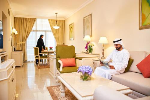 迪拜迪拜巴沙海兹美居公寓式酒店的一个人坐在客厅里