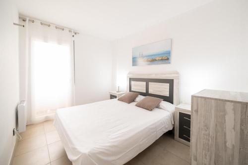 莱斯卡拉Apartment Meritxell的白色的卧室设有一张大床和一个窗户