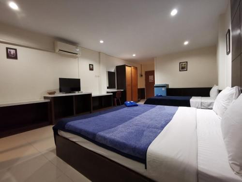 宋卡Ban Kaew Guesthouse Songkhla的酒店客房设有两张床和电视。