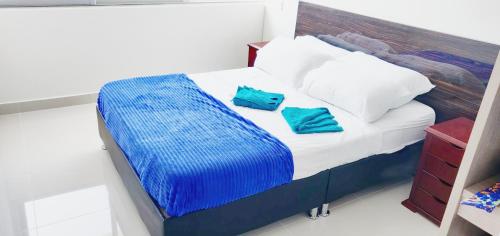 吉拉尔多特Condominio peñazul la morada lo mejor的床上有2个蓝色枕头