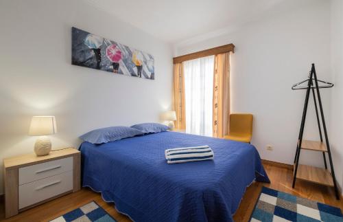 蓬塔德尔加达BellaVista Apartment的一间卧室配有蓝色的床和蓝色的毯子