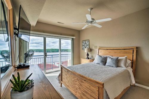 奥沙克湖Waterfront Lake Ozark Condo with Deck and Pools的一间卧室设有一张床和一个大窗户