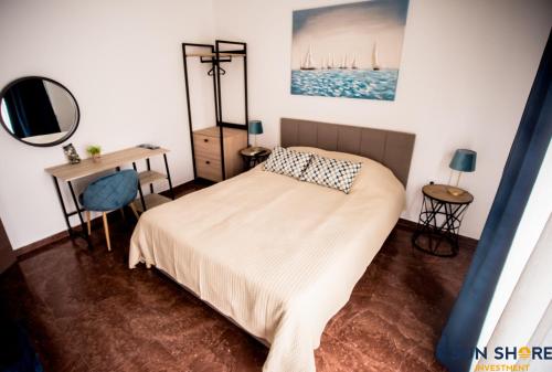 哈尔基斯Explore Greece from Lovely City Centre Apartment的一间卧室配有一张床、一张书桌和一面镜子