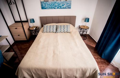 哈尔基斯Explore Greece from Lovely City Centre Apartment的卧室内的一张床位,配有两张桌子和两盏灯