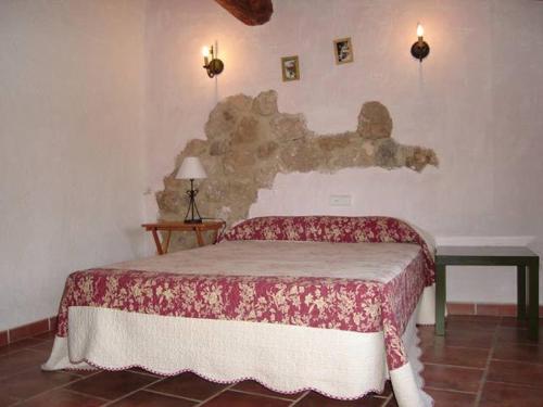 莱图尔Casa Rural Albayacín的一间卧室配有一张带红白毯子的床