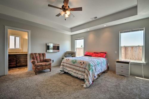 梅德福Cozy Home with Yard - 3 Mi to Downtown Medford!的一间卧室配有一张床、一把椅子和吊扇