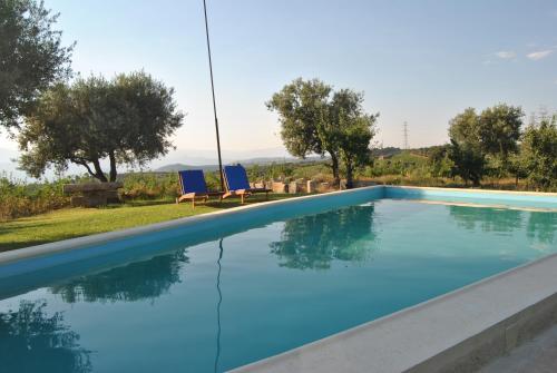 阿马马尔圣米格尔杜罗旅馆的一个带两把蓝色椅子和树木的游泳池
