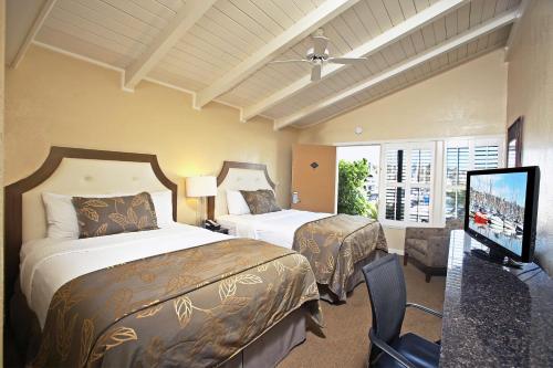圣地亚哥棕榈岛海滨贝斯特韦斯特PLUS酒店的酒店客房设有两张床和一台平面电视。