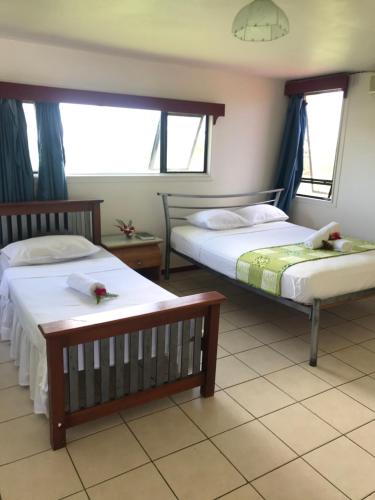 努库阿洛法汤加假日别墅 的一间卧室设有两张床和两个窗户。