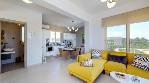 普拉塔尼亚斯Liberty & Freedom Luxury Villas的一间带黄色沙发的客厅和一间厨房