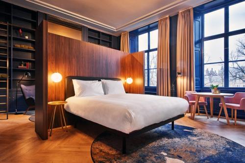 海牙Staybridge Suites The Hague - Parliament, an IHG Hotel的酒店客房带一张床、一张桌子和椅子