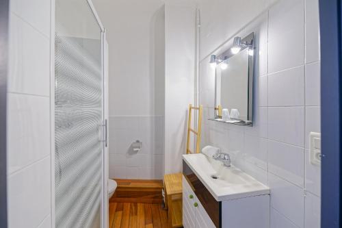 巴约讷哥特巴斯克酒店的白色的浴室设有水槽和淋浴。