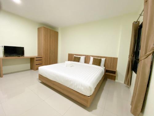奈扬海滩Nai Yang Residence的一间卧室配有一张大床和电视