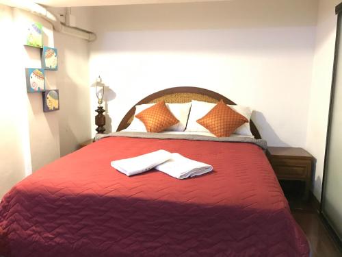 清迈Bee Friend Hostel的一间卧室配有红色的床和2条毛巾