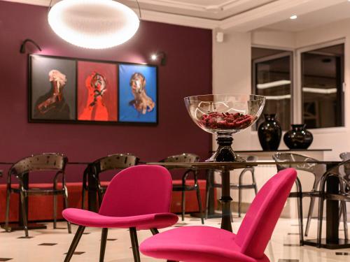 尼什嘉尼艺术洛夫特酒店的用餐室配有粉红色的椅子和桌子