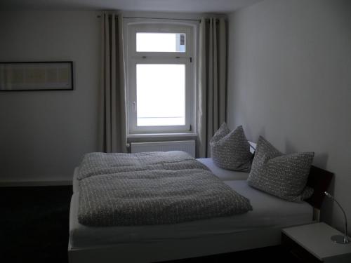 施派尔Ferienwohnung Speyer的卧室配有带枕头的床铺和窗户。