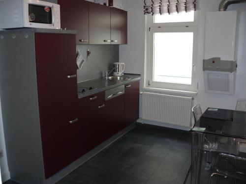 施派尔Ferienwohnung Speyer的厨房配有棕色橱柜和窗户