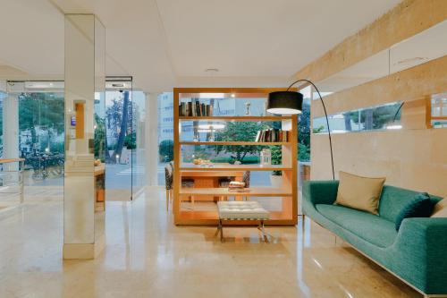 马略卡岛帕尔马Hesperia Ciudad de Mallorca的客厅配有绿色沙发和椅子