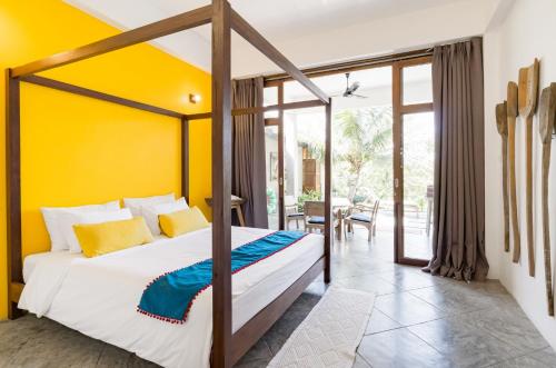 湄林平泳池2号别墅的一间卧室设有一张床和黄色的墙壁