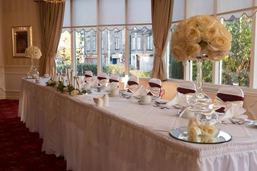 柯科迪维多利亚酒店的一张长长的白色桌子,上面有花