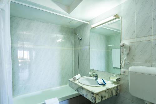 卡门港BelleVue Aquarius的白色的浴室设有水槽和镜子