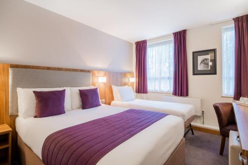 伦敦品质汉普斯蒂德酒店的酒店客房配有两张带紫色枕头的床