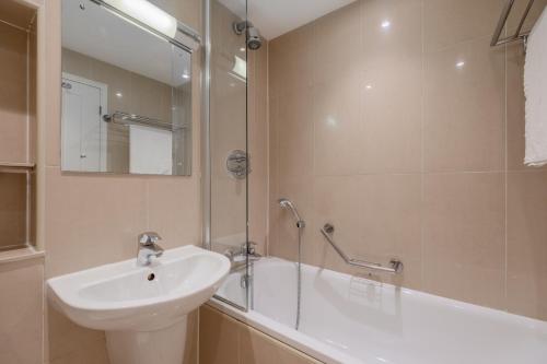 伦敦品质汉普斯蒂德酒店的浴室配有水槽、淋浴和浴缸。