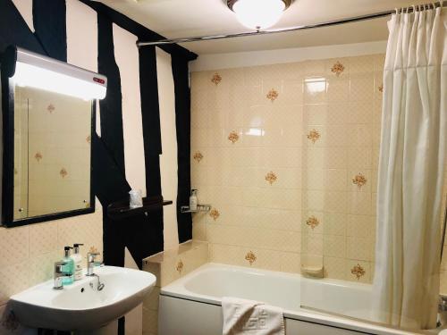 科尔切斯特布洛克红狮酒店的浴室配有盥洗盆、浴缸和盥洗盆