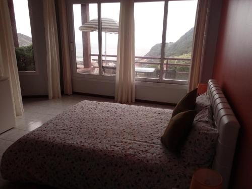 马希库Moradia Cor de Rosa的一间卧室设有一张床和一个大窗户
